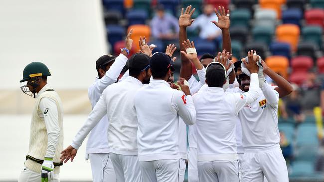 Usman Khawaja (left) trudges off after being dismissed for a duck as Sri Lanka players celebrate. Picture: AFP