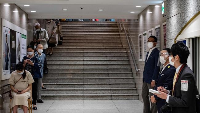 Japanese observe social distancing as customers line up to enter the reopened Matsuya department store in Tokyo on Monday. Picture: AFP