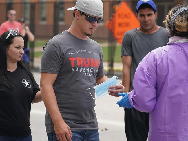 An attendee receives a face mask prior to entering a political rally for President Donald Trump. Picture: AFP