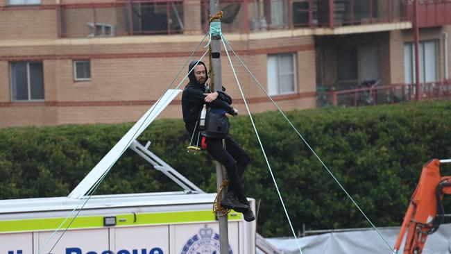 The man photographed hanging from the pole. Picture: Jeremy Piper