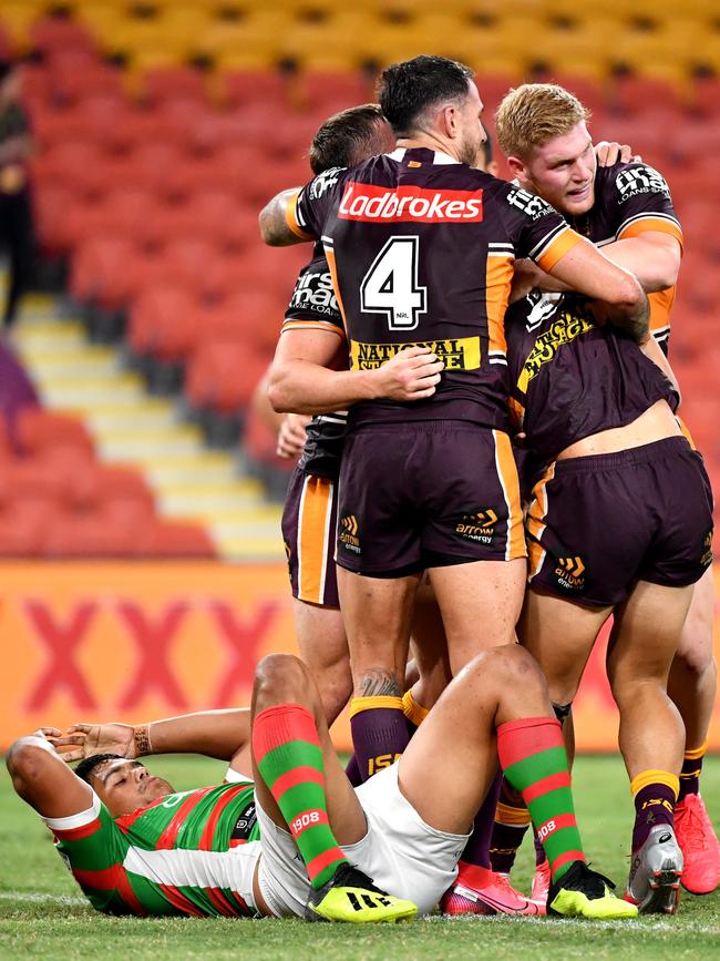 Latrell Mitchell (left) watches on as the Broncos celebrate a try. Picture: AAP Image/Darren England