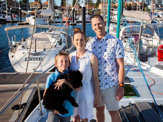 Natalie Feil and Ben Morgan, with their son Edison next to their yacht Aquila at 35 South Marina. Pic: SUPPLIED