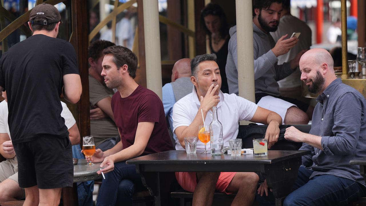 Customers smoking while sitting outdoors in a pub in Soho, London. Picture: Getty Images