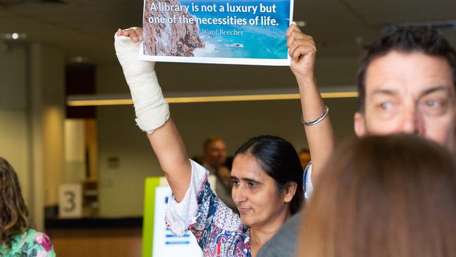 Surinder Kaur holding up a sign outside a Council meeting in 2019 in support of improved library services for the region.