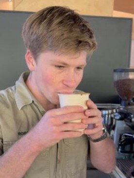 Trying his first cup of coffee ever.