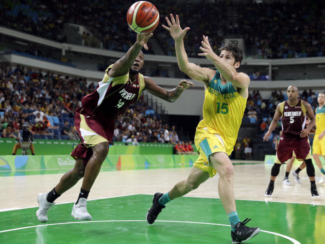 Australia's Damian Martin (15) catches a pass in front of Venezuela's Miguel Ruiz, left, during a basketball game at the 2016 Summer Olympics in Rio de Janeiro, Brazil, Sunday, Aug. 14, 2016. (AP Photo/Charlie Neibergall)