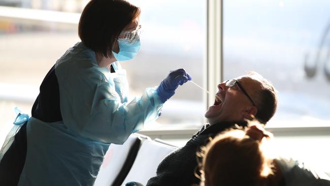 NSW Health workers screen returning passengers at Sydney Airport. Picture: David Swift