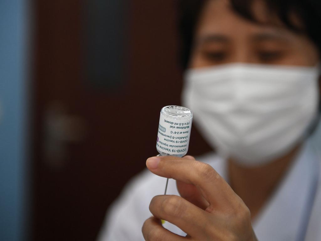 A health worker prepares a dose of the AstraZeneca vaccine. (Photo by Nhac NGUYEN / AFP)