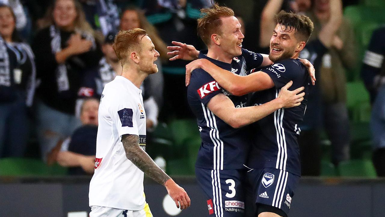 Corey Brown of the Victory (centre) celebrates with teammate Terry Antonis (right) after scoring a goal as Jack Clisby of the Mariners looks on. (AAP Image/George Salpigtidis)