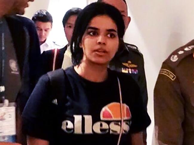 CORRECTION - This handout picture taken and released by the Thai Immigration Bureau on January 7, 2019 shows 18-year-old Saudi woman Rahaf Mohammed al-Qanun (C) being escorted by a Thai immigration officer (R) and United Nations High Commissioner for Refugees (UNHCR) officials at Suvarnabhumi international airport in Bangkok. - Rahaf Mohammed al-Qunun, seeking asylum has left Bangkok airport "under the care" of the UN refugee agency, a Thai official said on January 7, following her desperate plea against deportation. (Photo by Handout / Thai Immigration Bureau / AFP) / -----EDITORS NOTE --- RESTRICTED TO EDITORIAL USE - MANDATORY CREDIT "AFP PHOTO / THAI IMMIGRATION BUREAU" - NO MARKETING - NO ADVERTISING CAMPAIGNS - DISTRIBUTED AS A SERVICE TO CLIENTS / “The erroneous mention[s] appearing in the metadata of this photo has been modified in AFP systems in the following manner: [adding handout restrictions]. Please immediately remove the erroneous mention[s] from all your online services and delete it (them) from your servers. If you have been authorized by AFP to distribute it (them) to third parties, please ensure that the same actions are carried out by them. Failure to promptly comply with these instructions will entail liability on your part for any continued or post notification usage. Therefore we thank you very much for all your attention and prompt action. We are sorry for the inconvenience this notification may cause and remain at your disposal for any further information you may require.”