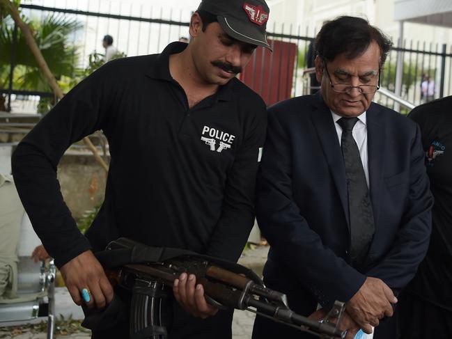 A policeman escorts Saif-ul-Mulook (R), Pakistani lawyer of Christian mother Asia Bibi, as he leaves the Supreme Court after the final hearing in Islamabad on October 8, 2018. - Pakistan's Supreme Court said it had reached a judgement on October 8 after hearing the final appeal of a Christian mother on death row for blasphemy, but that it will announce its ruling later in the notorious case, which has gone all the way to the Vatican. (Photo by AAMIR QURESHI / AFP)