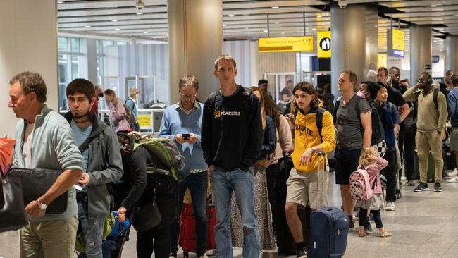 Travellers wait in a long queue to pass through the security check at Heathrow in June. Picture: Getty Images