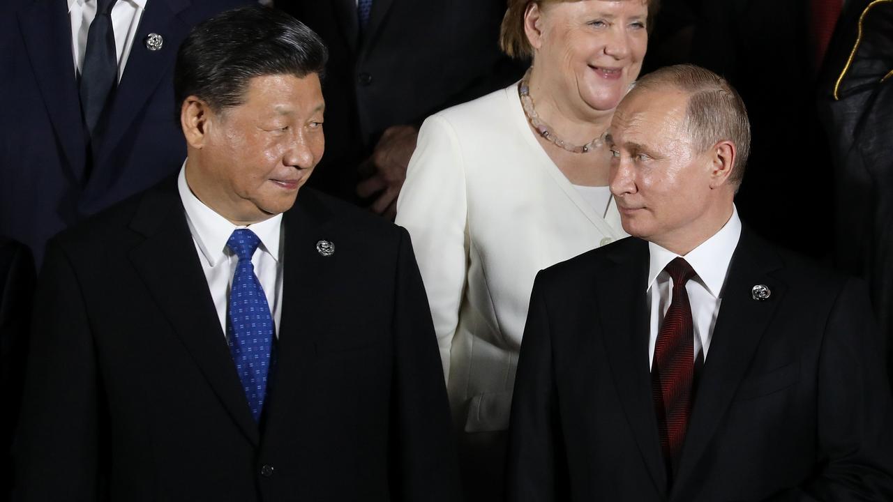 German Chancellor Angela Merkel stands behind Russian President Vladimir Putin (front R) and Chinese President Xi Jinping in Osaka in 2019. Picture:Dominique JACOVIDES / AFP