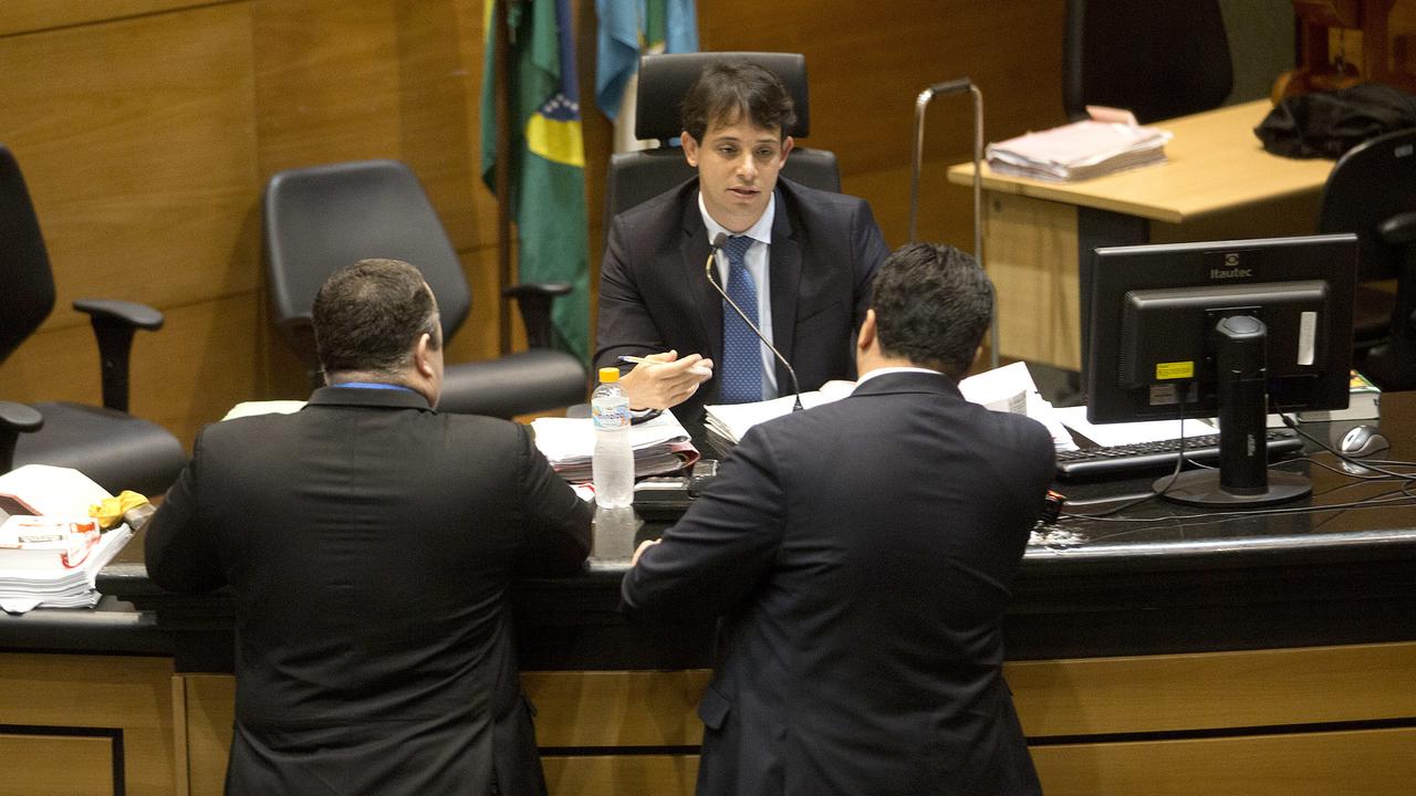 Brazilian judge Daniel Werneck Cotta talks with lawyers before the start of a pre-trial hearing of Mario Marcelo Santoro at a Rio de Janeiro court.