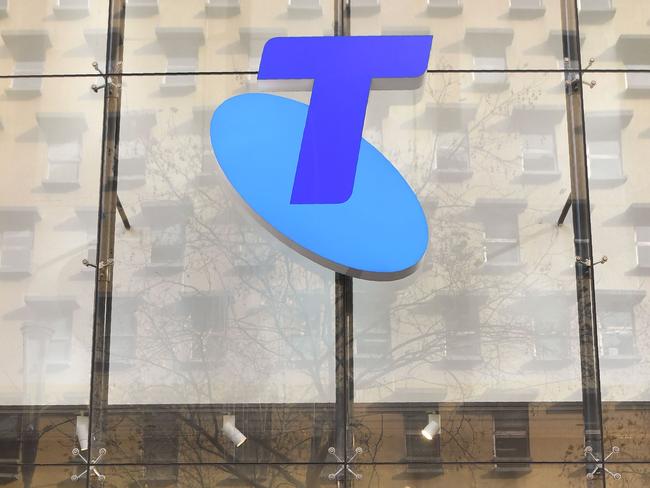 A man speaks on his phone as he walks past a Telstra store on Melbourne's central business district on June 20, 2018. AFP PHOTO / William WEST