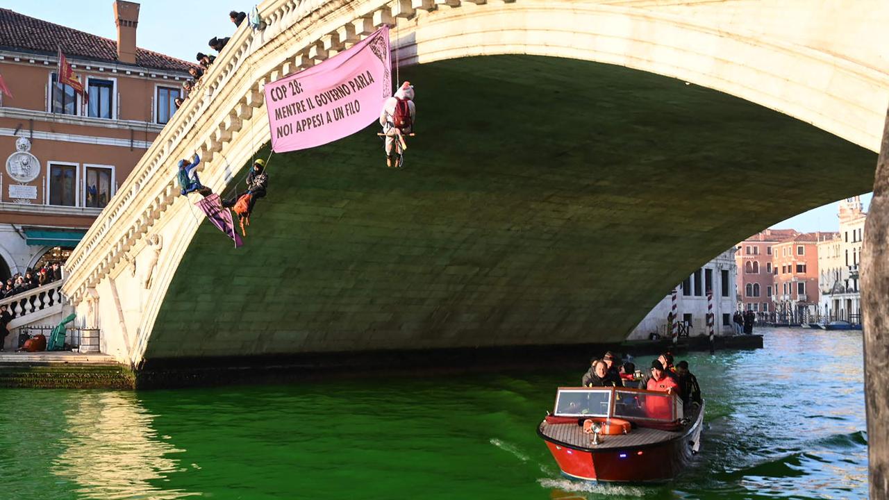 Three Extinction Rebellion activists hung from the Rialto Bridge. Picture: Marco Sabadin / AFP