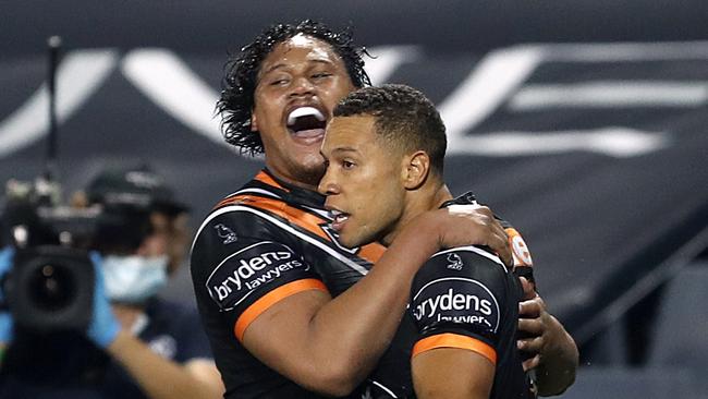 Luciano Leilua (left) reacts with Moses Mbye of the Tigers after Mbye scored a try during the Round 6 NRL match between the Wests Tigers and the North Queensland Cowboys at Campbelltown Stadium in Sydney, Saturday, June 20, 2020. (AAP Image/Brendon Thorne) NO ARCHIVING, EDITORIAL USE ONLY