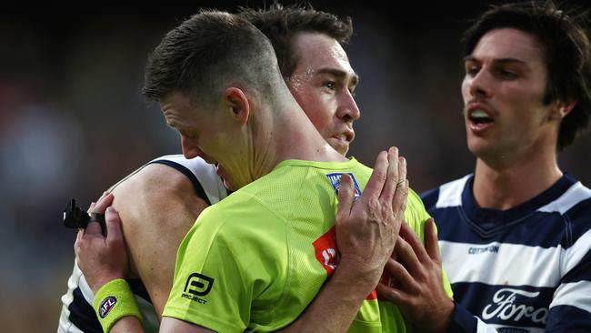 Jeremy Cameron helps boundary umpire Matthew Tomkins to his feet. Picture: Michael Klein