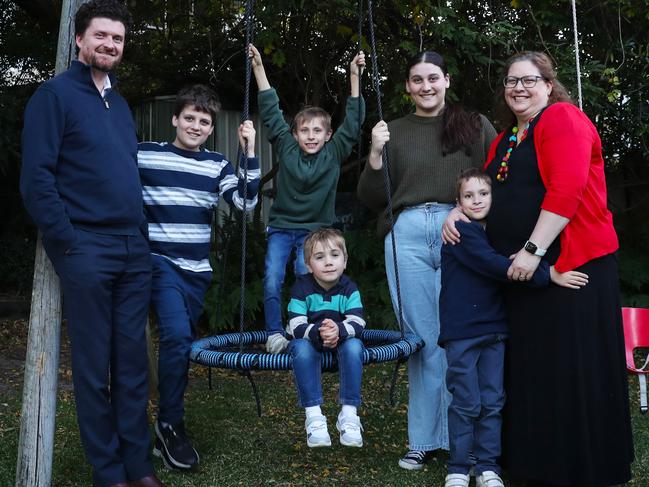 1/6/23: Sarah Lainson and her husband Simon with their adopted boys Caleb 9,(blue top) Memphis 8 (green top) and Moe 5 and their biological children Ben 12 and Amelia18 (both with dark hair) at their home in West Wollongong. John Feder/The Australian.