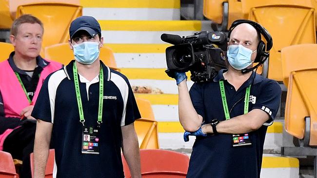 Channel 9 TV cameramen are wearing safety mask and gloves at the footy.