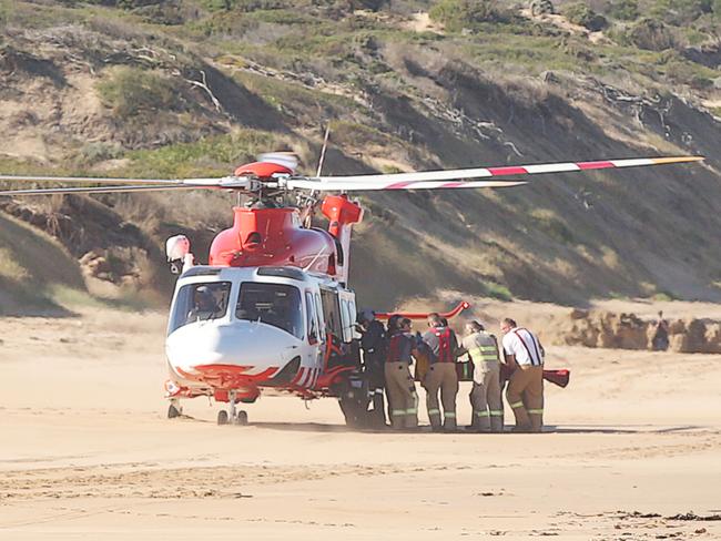 A casualty is carried to the air ambulance. Helicopter crash in the shallows between Ocean Grove and Point Londsdale. Picture: Alan Barber