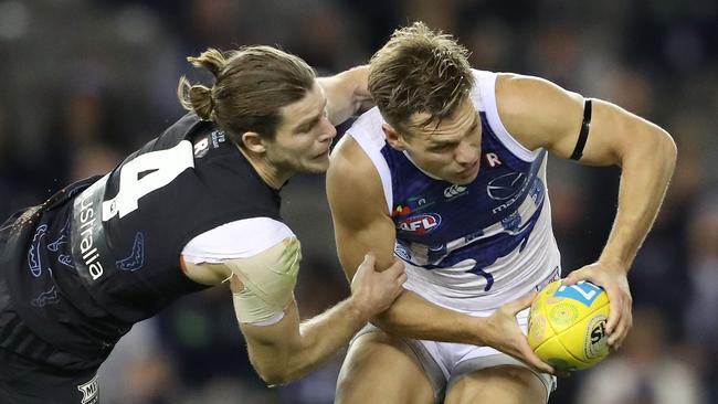 North Melbourne’s Shaun Higgins tries to break a lunging tackle from Bryce Gibbs. Picture: Getty Images