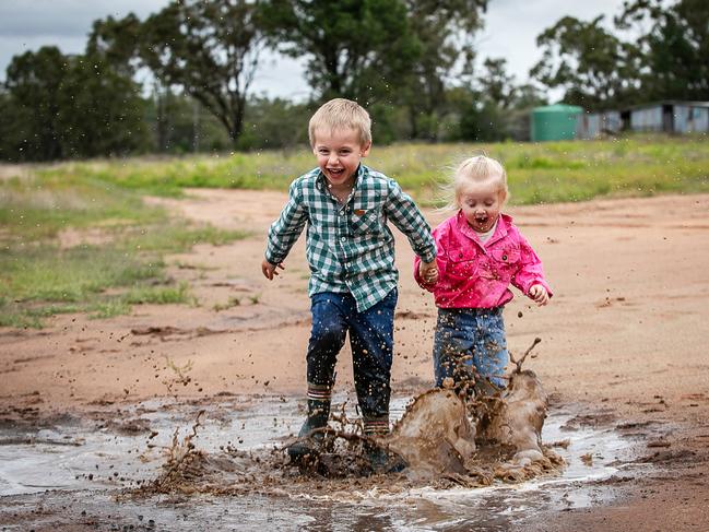 Wally and Zoe Joliffe playing in puddles after significant rainfall in the Roma area. Picture: Katrina Ayers