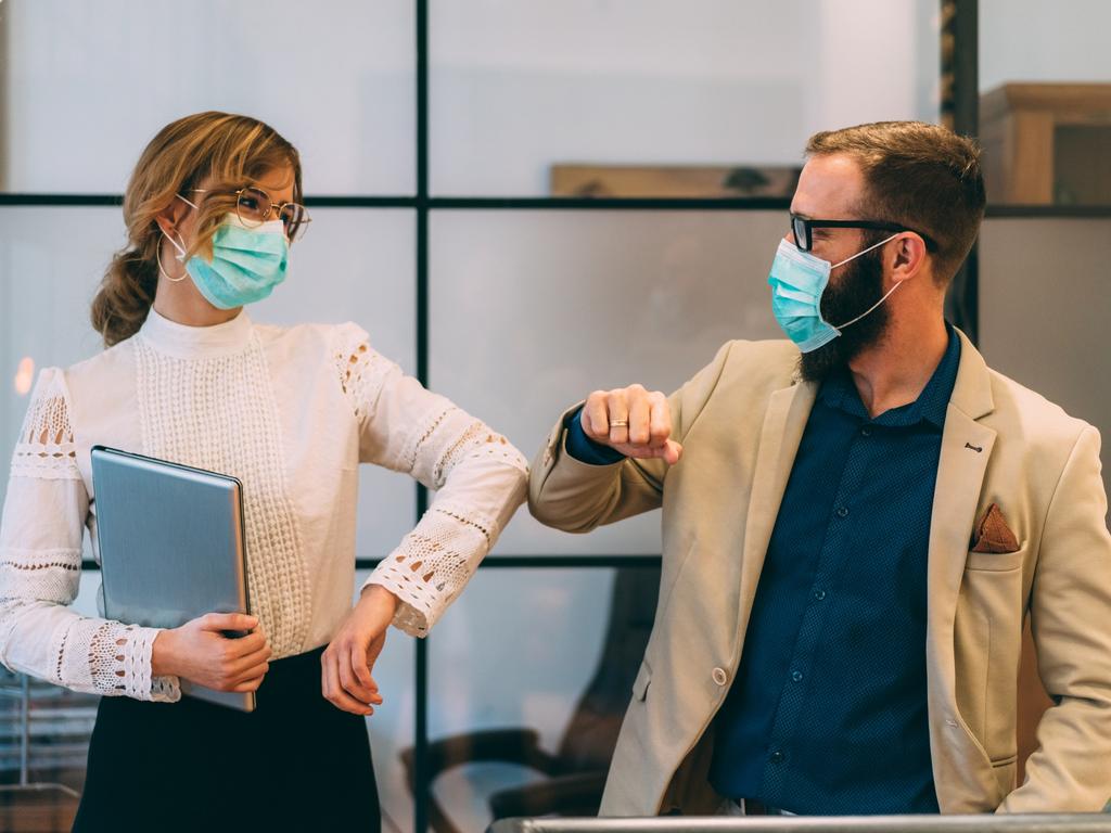 Colleagues in the office practising alternative greeting for safety and protection during COVID-19