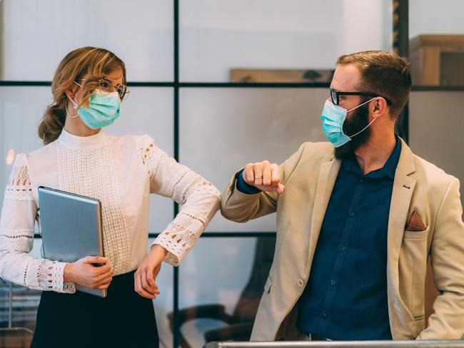 Colleagues in the office practising alternative greeting for safety and protection during COVID-19