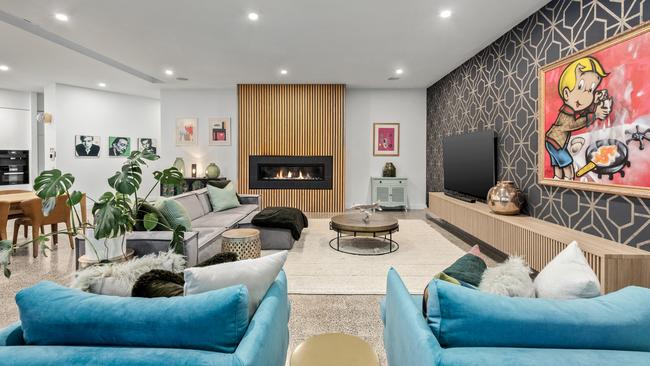 The gas log fireplace has a timber surround in the main living room.