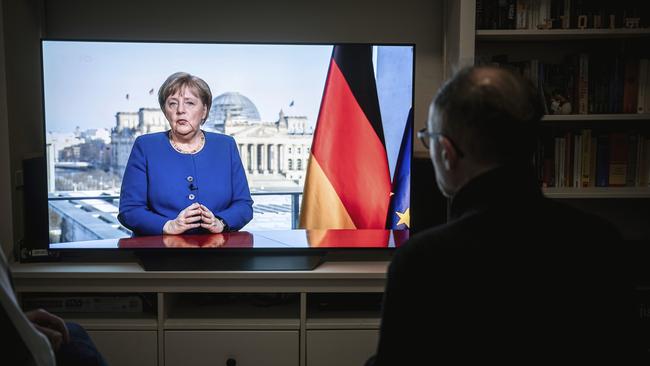 A German citizen watches the direct TV address of Chancellor Angela Merkel. Picture: AP