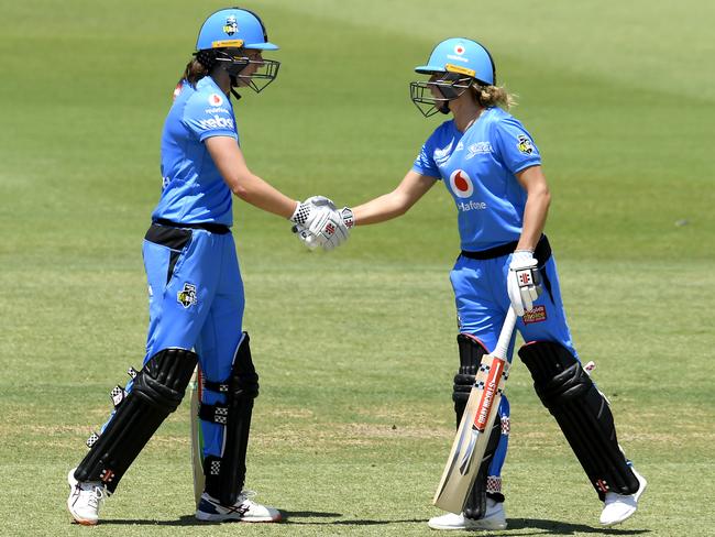 Strikers Tahlia McGrath, left, celebrates her half century with team-mate Lauren Winfield during the WBBL win against the Perth Scorchers at Brisbane’s Allan Border Field. Picture: Getty Images