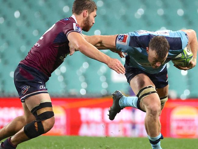 Jack Dempsey (R) of the NSW Waratahs tries to avoid a tackle by Josh Flook from the Queensland Reds during the Super Rugby match at the Sydney Cricket Ground (SCG) on August 8, 2020. (Photo by DAVID GRAY / AFP)