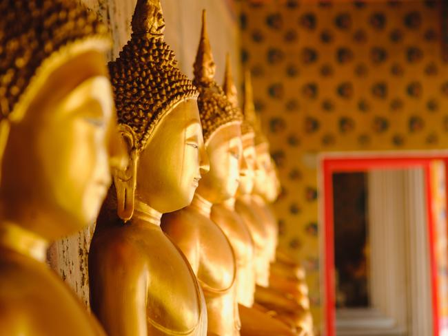 ESCAPE:  Row of Buddha statue in long corridor at Wat Arun temple which is a public place, Bangkok Thailand. Picture: Istock