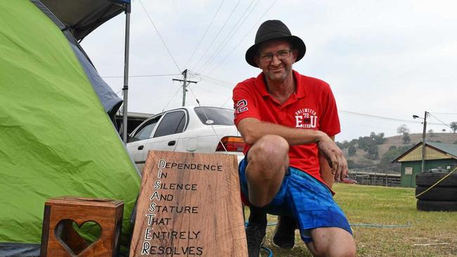 OUR SAVIOUR: Displaced Terania Creek residents Declan and Terri said local man Michael Ryan (pictured) has been their saviour. Michael crafted this beautiful wooden sign to help raise their spirits while they were camping at the showgrounds. Picture: Jackie Munro