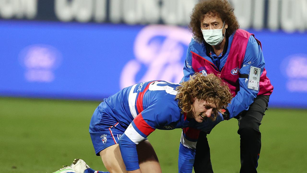 Aaron Naughton is attended to by a doctor after a heavy hit against Geelong.