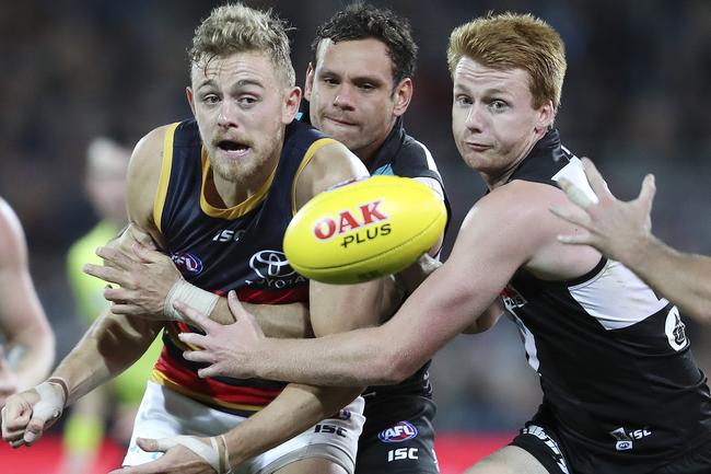 Crows Hugh Greenwood handballs under pressure from Port Adelqaide’s Steven Motlop and Willem Drew in Showdown 46 at Adelaide Oval. Picture Sarah Reed