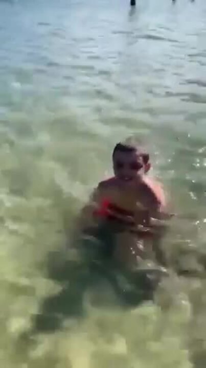 Redcliffe autistic boy Jai Warner makes a splash in a swimming enclosure at North Stradbroke Island. The enclosure was the only place he could swim without a lifejacket, which the NDIS has failed to fund.