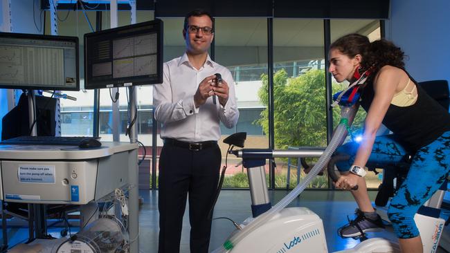 Dr Nir Eynon studies Shanie Landen, exercising on the bike. Picture: Jay Town.