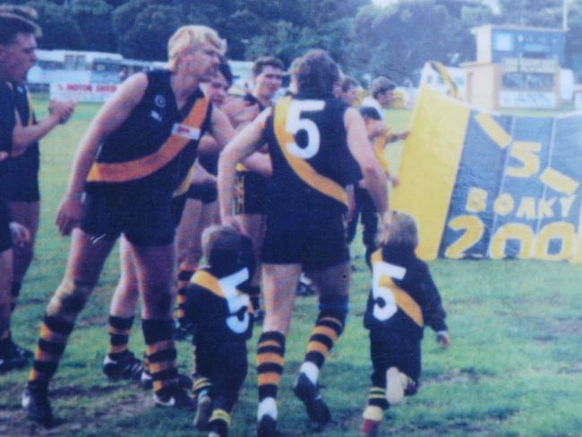 Roger Boak running out for his 200th game with children Travis and Sarah.