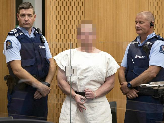 (FILES) In this file photo taken on March 16, 2019 Brenton Tarrant, the man charged in relation to the Christchurch massacre, makes a sign to the camera during his appearance in the Christchurch District Court. - The Australian charged with murder in the mass shootings at two New Zealand mosques appears "rational" and aware of the situation, his ex-lawyer told AFP on March 18, 2016. Duty lawyer Richard Peters represented the 28-year-old during a preliminary court hearing, but was dropped after Tarrant indicated he wanted to represent himself. (Photo by Mark Mitchell / POOL / AFP) / EDS NOTE HIS FACE MUST BE PIXELATED..ONLY HIS FACE--