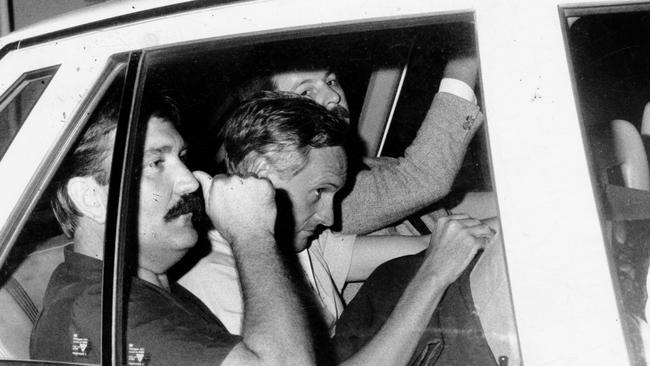 John Malcolm West, then 37, sitting in the back seat of an Adelaide CIB motor car flanked by detectives in 1985.