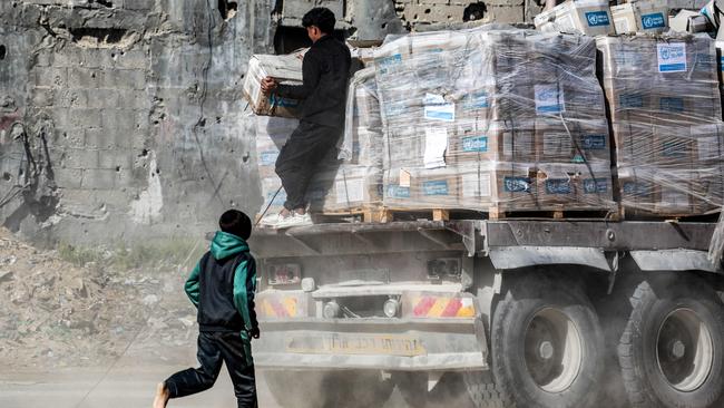 A boy chases a truck carrying humanitarian aid by the United Nations Relief and Works Agency for Palestine Refugees in southern Gaza. Picture: AFP