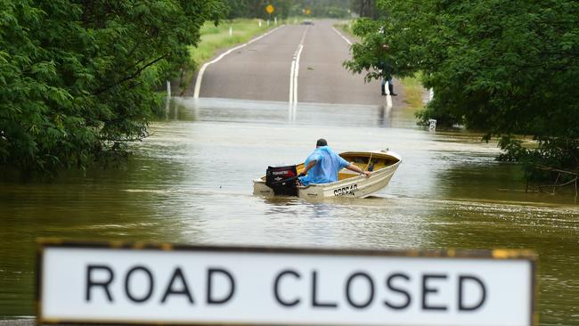 Wet weather in Townsville.  Poultry farmer Jeff Ironside heads back for more after bringing people across  the Bohle River, cut by flood water at Allambie Lane. Picture: Evan Morgan