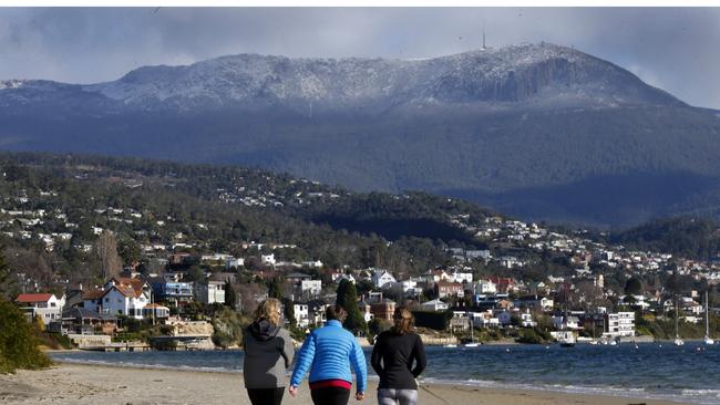 hobart weather picture of light snow on Mt Wellington with walkers on Sandy bay beach