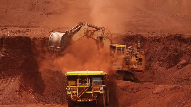 An excavator loads ore into an autonomous dump truck at Fortescue Metals Group Ltd.'s Solomon Hub mining operations in the Pilbara region, Australia, on Thursday, Oct. 27, 2016. Shares in Fortescue, the world's No. 4 iron ore exporter, have almost trebled in 2016 as iron ore recovered, and the company cut costs and repaid debt. Photographer: Brendon Thorne/Bloomberg via Getty Images