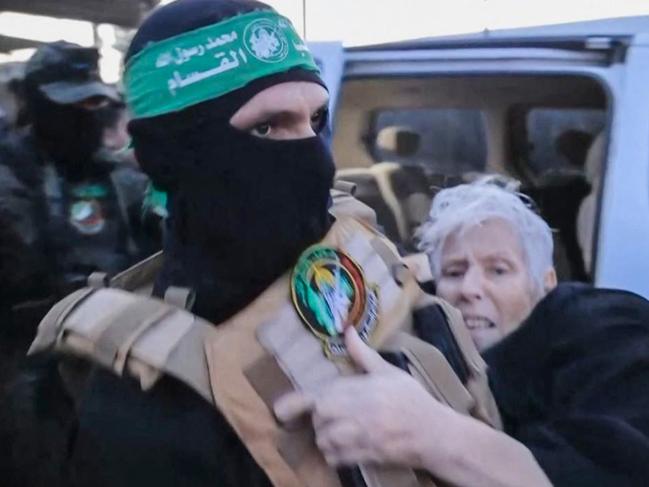An image grab from a handout video released by the Hamas Media Office shows a member of its Al-Qassam Brigades handing carrying a hostage over to officials from the International Committee of the Red Cross in Gaza on November 24, 2023, ahead of their transfer to Israel. After 48 days of gunfire and bombardment that claimed thousands of lives, the first hostages to be released under a truce deal between Israel and Hamas were handed over on November 24, both sides said, nearly seven weeks after they were seized. (Photo by HAMAS MEDIA OFFICE / AFP) / == RESTRICTED TO EDITORIAL USE - MANDATORY CREDIT "AFP PHOTO / HO / HAMAS MEDIA OFFICE" - NO MARKETING NO ADVERTISING CAMPAIGNS - DISTRIBUTED AS A SERVICE TO CLIENTS ==