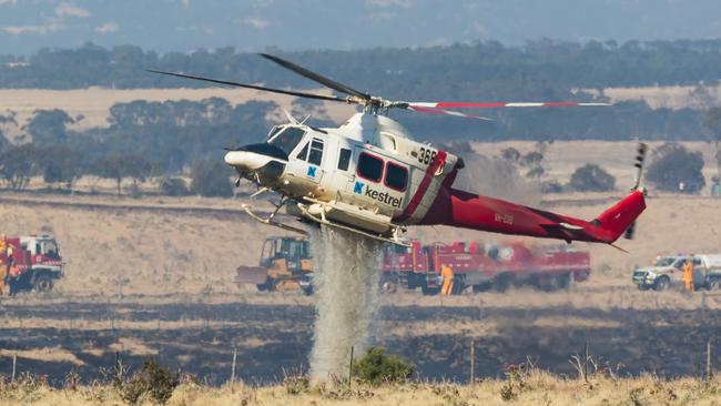 A water bombing helicopter battles an out-of-control grass fire at Sunbury on New Year's Day, 2020. Picture: Dave Soderstrom Aviation Spotters Online