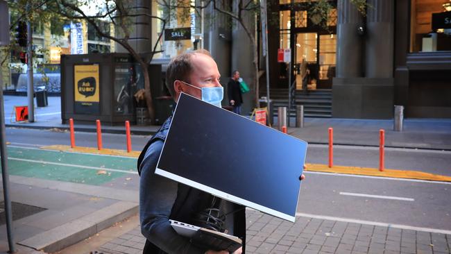 Brett Scallan takes his computer home so he can work from home as Sydney CBD prepares to go into lockdown for a week after a spike in Covid cases. PPicture: John Feder.