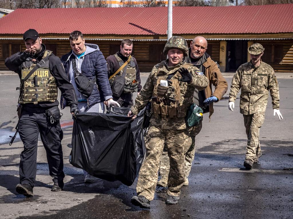 Ukrainian soldiers move bodies after a rocket attack killed more than 30 people at a train station that was being used for civilian evacuations in Kramatorsk, eastern Ukraine. Picture: Fadel Senna / AFP.